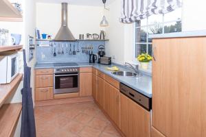 a kitchen with a sink and a stove top oven at Ferienhaus Satelsrönne 23 - Wattlaeufer in Duhnen