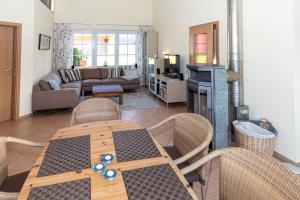 a living room with a wooden table and chairs at Ferienhaus Satelsrönne 23 - Wattlaeufer in Duhnen
