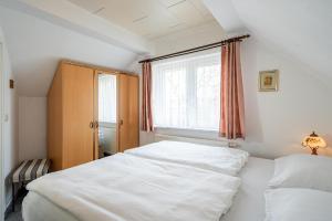 ein Schlafzimmer mit zwei weißen Betten und einem Fenster in der Unterkunft Ferienwohnung Sellin 35 in Sellin