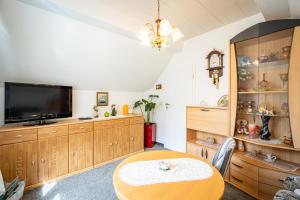ein Esszimmer mit Tisch und Fernseher in der Unterkunft Ferienwohnung Sellin 35 in Sellin