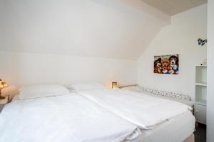 ein weißes Bett in einem weißen Schlafzimmer mit weißen Wänden in der Unterkunft Ferienwohnung Sellin 35 in Sellin