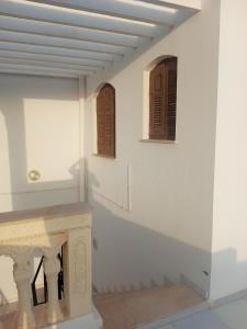 a room with two wooden windows and a table at Studio AMINE in Mahdia