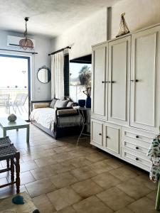 a bedroom with a bed and a large white cabinet at Αριάδνη στούντιο με θέα in Anavyssos