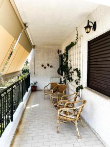 a patio with chairs and a table on a balcony at Αριάδνη στούντιο με θέα in Anavyssos
