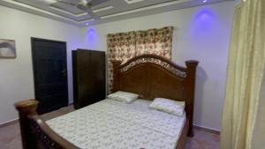 una camera da letto con un letto di legno in una stanza di Privacy & Comfort Your Home Away From Home- 2 Bedroom House Free WiFi close to Santasi-Kumasi a Kumasi