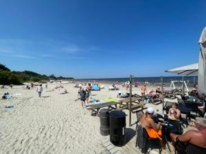 a group of people sitting on a beach at Kauguri apartment residence in Jūrmala