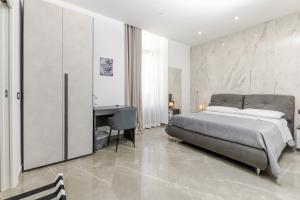 Un dormitorio con una cama y un escritorio. en Nova Suite, en Catania