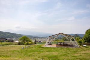a pavilion with a picnic table in a field at 里山でのんびり遊べる宿-風音翆舎 Kanon suisha in Kawaba
