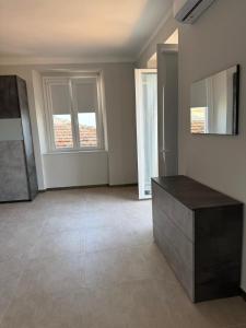 an empty room with two windows and a table at L'approdo di Odisseo in Pizzo