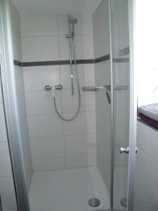 uma casa de banho com um chuveiro e uma porta de vidro em Ferienwohnung Knusperhaus em Xanten