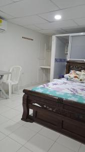 a bedroom with a bed in a room with a table at Hostal Casa Lara in Cartagena de Indias