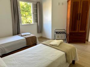 a bedroom with two beds and a window at Sol & Aconchego Paraty in Paraty +58 photos