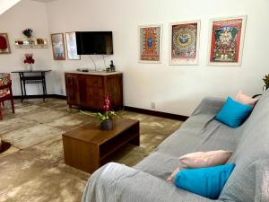 a living room with a couch and a tv at Sol & Aconchego Paraty in Paraty