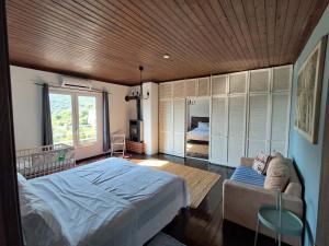 プラタモナスにあるAppartement Platamonのベッドとソファと窓のある寝室