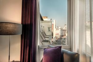 a room with a large window with a chair and a pillow at Apart by Broadway in Buenos Aires