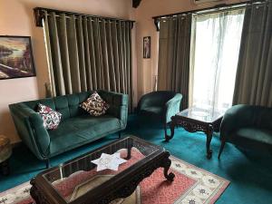 ブハーバンにあるBhurban Hillsのリビングルーム(緑のソファ、椅子付) +2枚の写真
