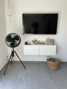 un salon avec une télévision sur un mur blanc dans l'établissement Ferienhaus Meerwunder, à Wangerland