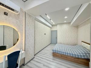a bedroom with a bed with a blue checked blanket at Жк Development in Bishkek