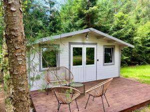 a cabin with a table and chairs on a wooden deck at Baltic Beach Cozy Tiny House B in Pērkone