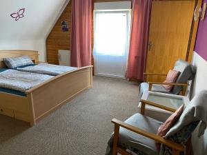een slaapkamer met een bed, een stoel en een raam bij Ferienwohnung 14 in Steinkirchen +14 foto's