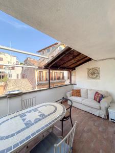 a balcony with a table and a couch at Attic Castel Sant'Angelo - Pantheon in Rome
