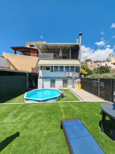 a backyard with a swimming pool and a house at Casa Joana in Canyelles