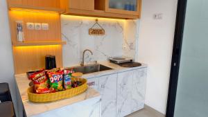 a kitchen with a sink and a basket of chips at Vila Kelapa Gading Banjarbaru Syariah in Martapura
