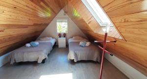 a attic room with two beds and a window at Brennig in Penmarch