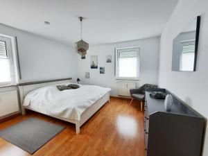 a white bedroom with a bed and a desk at Haus Heidelbeere 22 in Graal-Müritz +8 photos