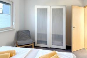 Un dormitorio con una cama y una silla y una ventana. en Ferienwohnung Kamske, en Lübbenau