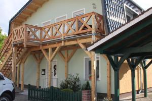 una casa con una terraza de madera encima en Ferienwohnung Kamske, en Lübbenau 4 fotos más