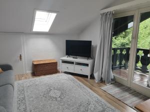 a living room with a flat screen tv on a white cabinet at Riverside Apartment in Garmisch-Partenkirchen