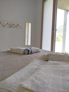 a white bedroom with a bed and a large window at Garden House in Sondrio