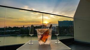 艾福雷诺德Mirage Beach Spa Hotel的阳台上的一张桌子上放着一杯饮料和两个酒杯