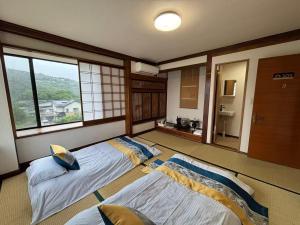 two beds in a room with two windows at 紅富士苑 in Yamanakako