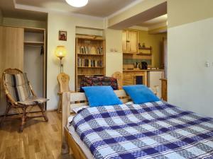 a bedroom with a bed and a chair and a kitchen at Oremusówka in Zakopane