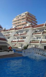 a large white building with a swimming pool in front of it at Apartment in Las Americas in Playa de las Americas