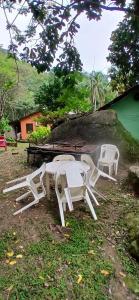 two white picnic tables and chairs in a yard at Camping Refugio SacodoCeu2026 in Saco do Ceu