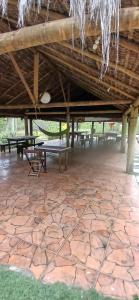a pavilion with picnic tables and a stone floor at Camping Refugio SacodoCeu2026 in Saco do Ceu