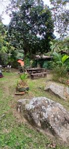 Una mesa de picnic y un banco en un patio. en Camping Saco do Céu, en Saco do Ceu
