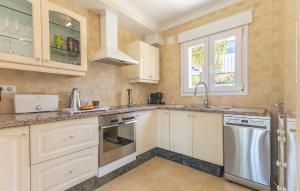 eine Küche mit weißen Schränken und Geräten aus Edelstahl in der Unterkunft Awesome Home In Orba With Wifi in Orba