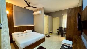 a bedroom with a bed and a tv in it at Ratna Residency in Udupi +11 photos