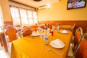 een eetkamer met een tafel met een geel tafelkleed bij Shamz Hotel in Isiolo