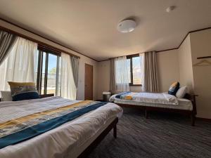 a hotel room with two beds and windows at 紅富士苑 in Yamanakako +42 photos