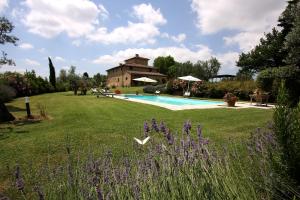 einen Garten mit Pool und ein Haus in der Unterkunft Archipettoli in San Casciano in Val di Pesa