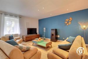 a living room with two couches and a tv at Les agapanthes in Ploemeur