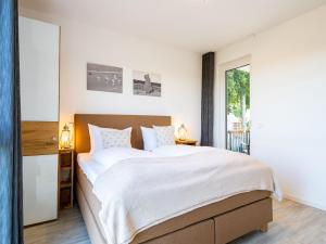 ein Schlafzimmer mit einem großen Bett und einem Fenster in der Unterkunft Bernsteinquartier - Wohnung 87 in Ostseebad Kölpinsee