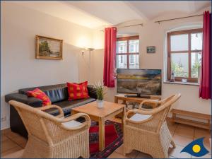 Una sala de estar con un sofá y un televisor. en Villa Ricarda Whg 02, en Ahlbeck