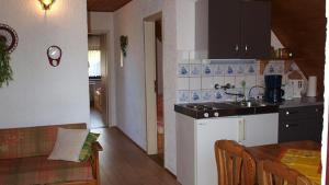een keuken met een wastafel en een tafel in een kamer bij Ferienwohnungen Klinkmüller in Fleißdorf