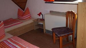 een kleine kamer met een bed, een stoel en een bureau bij Ferienwohnungen Klinkmüller in Fleißdorf